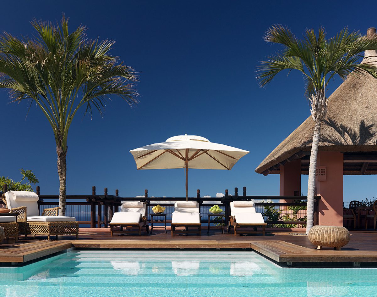 swimming pool surrounded by plush white sunbeds