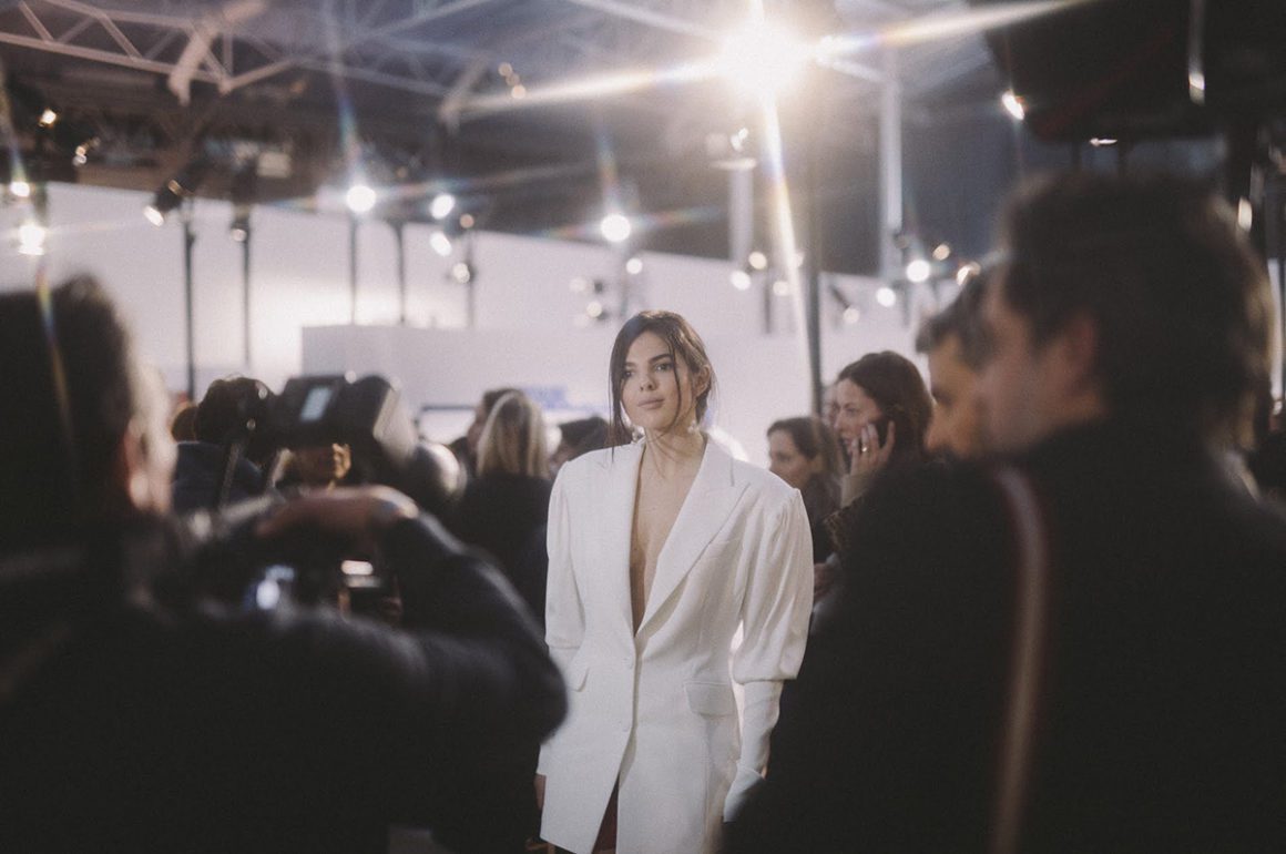 Model Emily Ratajkowski pictured wearing white suit surrounded by photographers