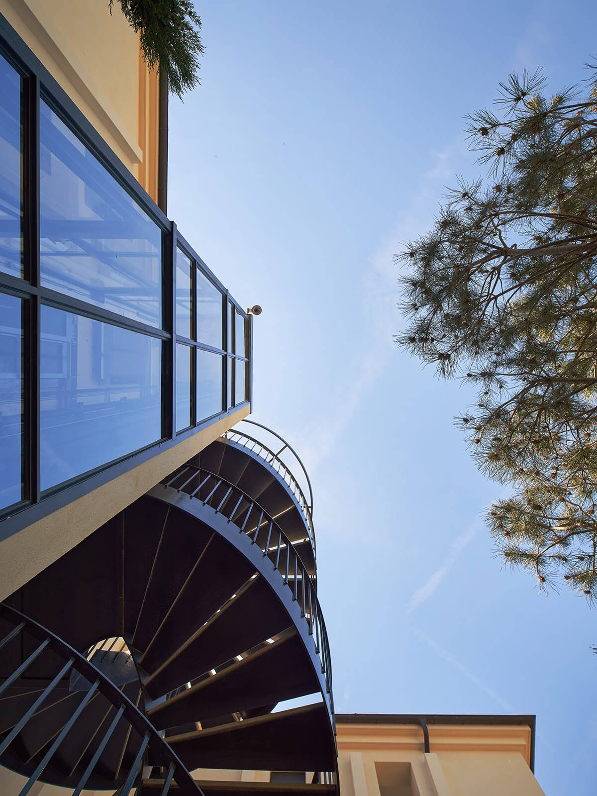 detail of spiral staircase and glass lift shaft on a building