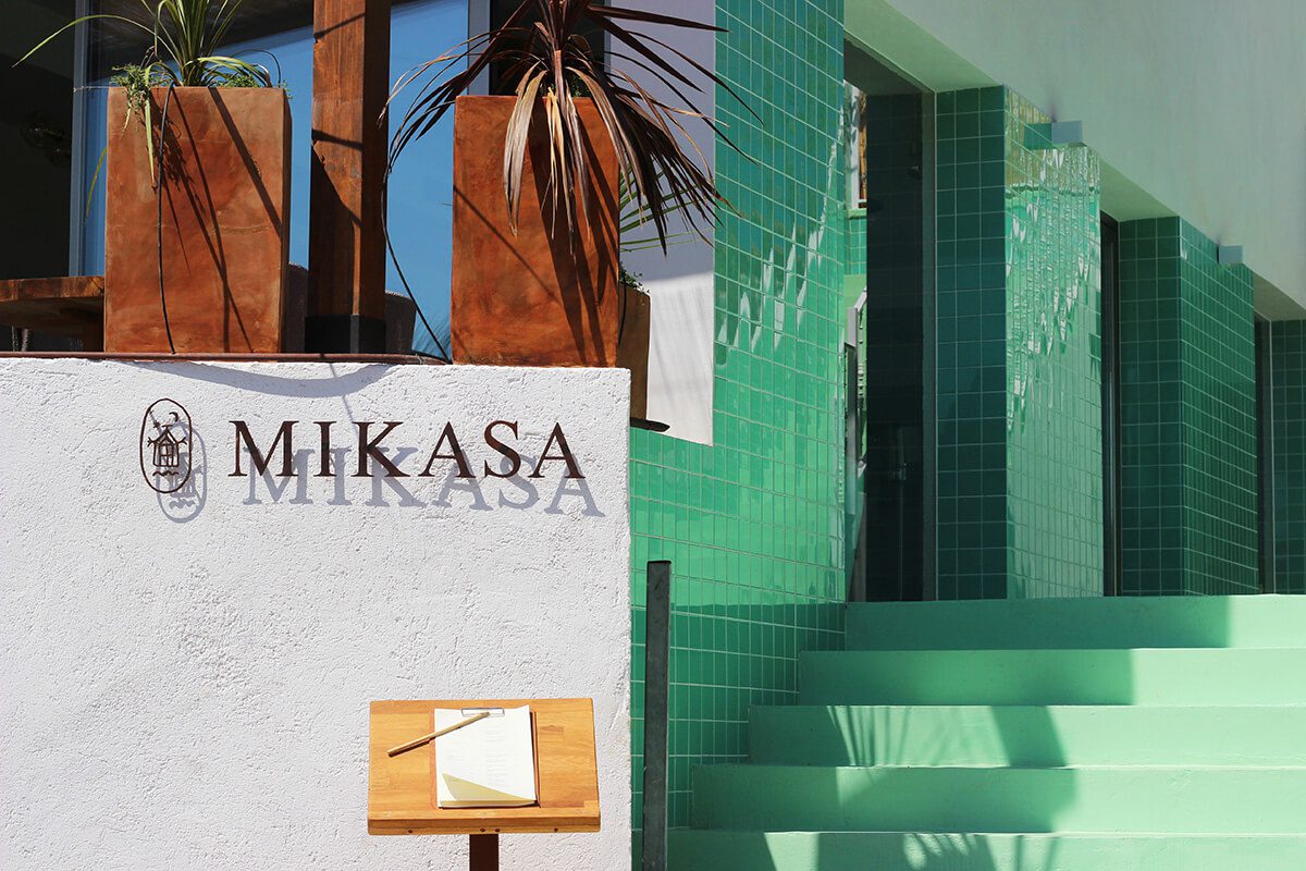 Colourful entrance to Mikasa with turquoise tiled staircase and the shadow of palms