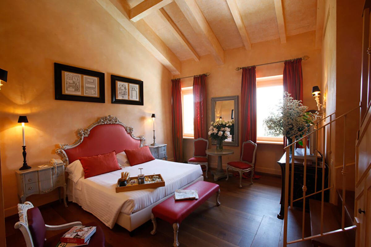 Luxury hotel bedroom with large double bed with breakfast tray and antique furniture