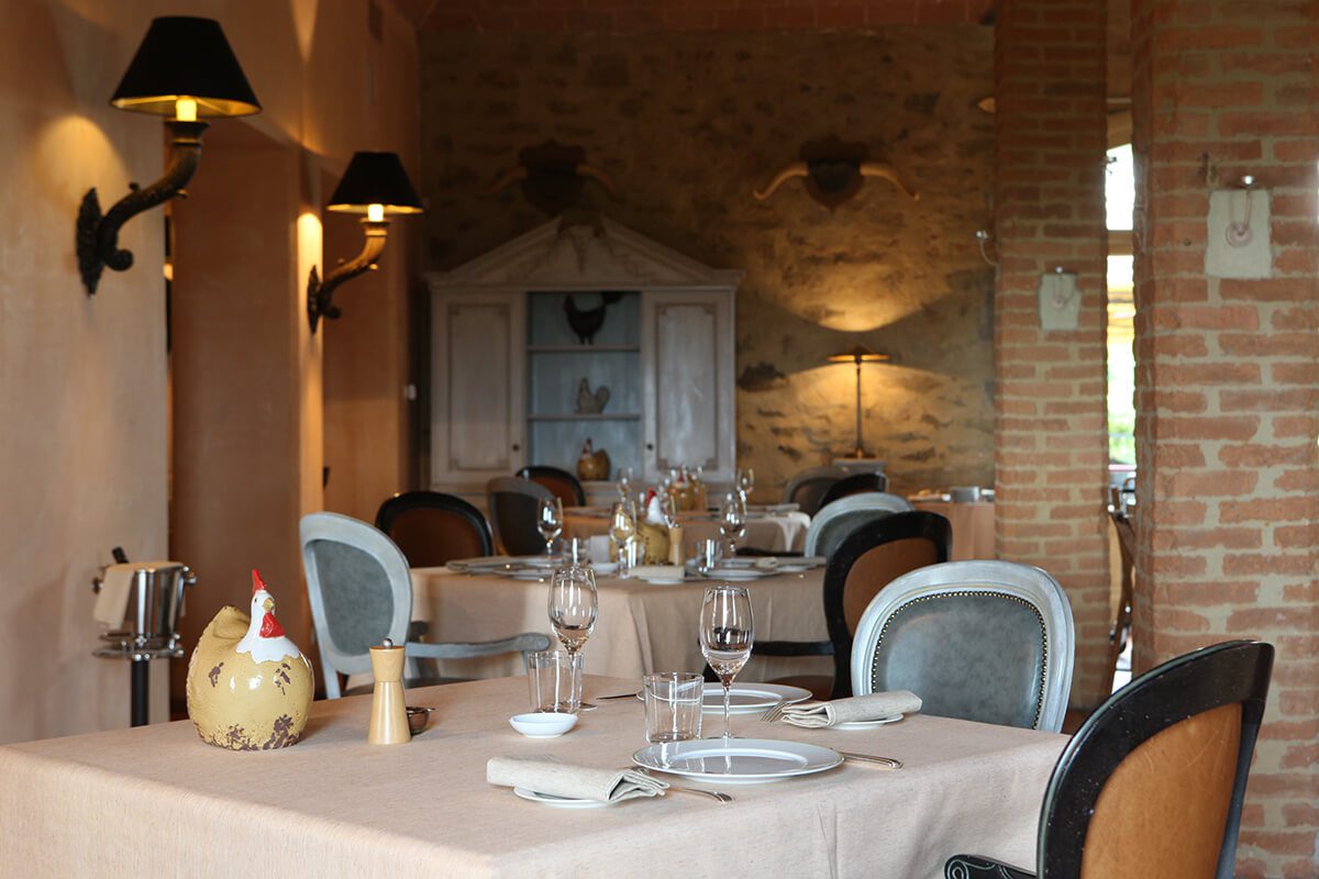 Luxury restaurant with tables laid for dinner and bare, brick walls