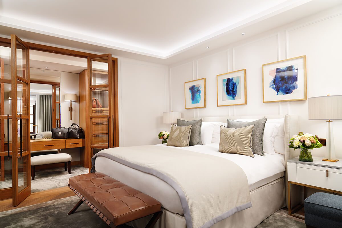 Luxury hotel bedroom with a double bed and open plan bathroom decorated in stylish neutral tones