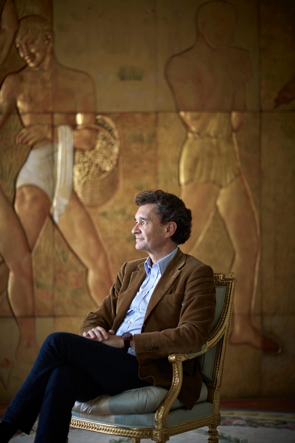 Portrait of Philippe Sereys de Rothschild sitting in front of a stone mosaic