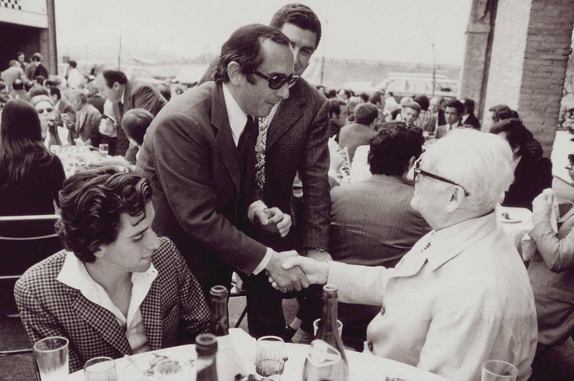 Vintage photograph of Jack Heuer of TAG Heuer swiss watches greeting Enzo Ferrari seated at a table