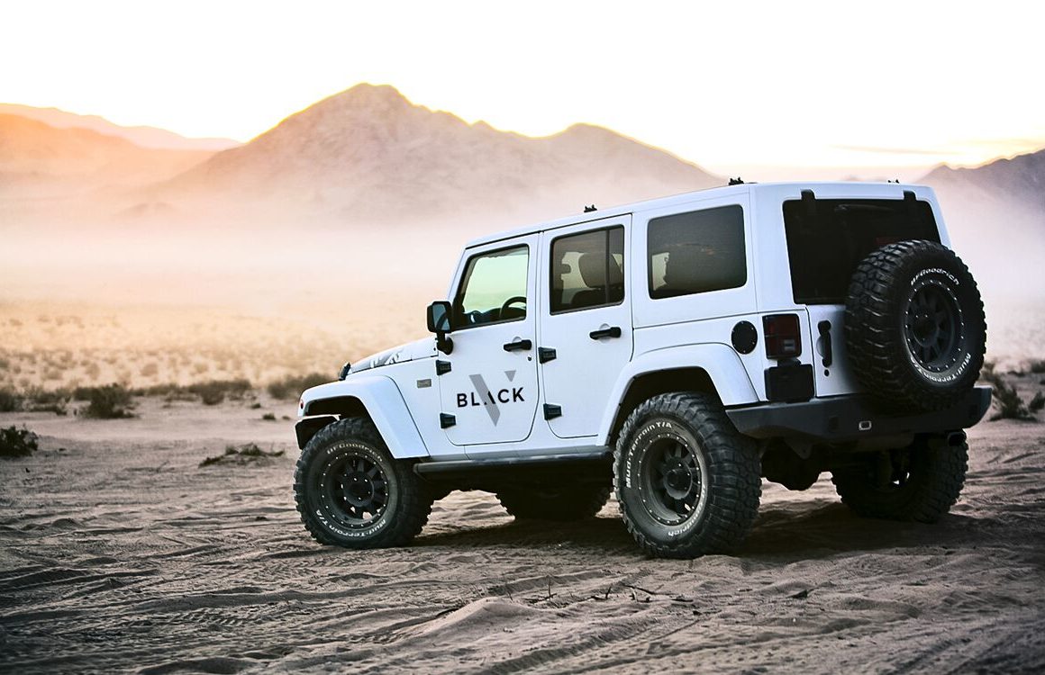 Velocity black branded truck in a desert facing sand dunes