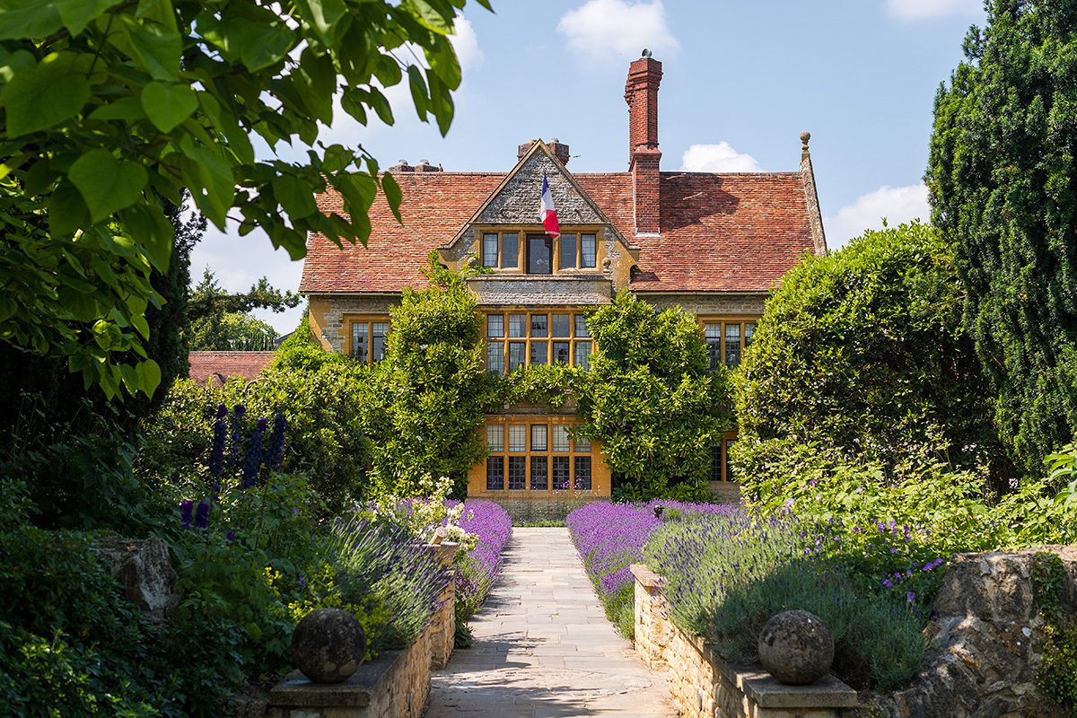 Entrance to grand country home through a flower garden