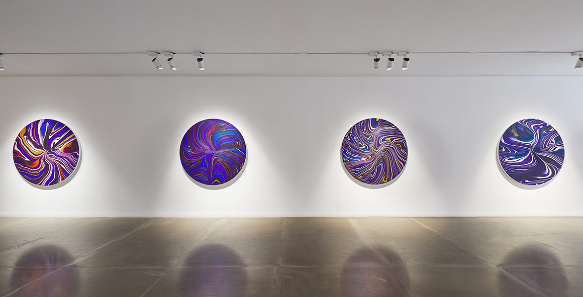 Installation view of a contemporary art exhibition with round canvases