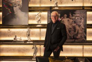 Man stood in front of sculptural wall in a hotel