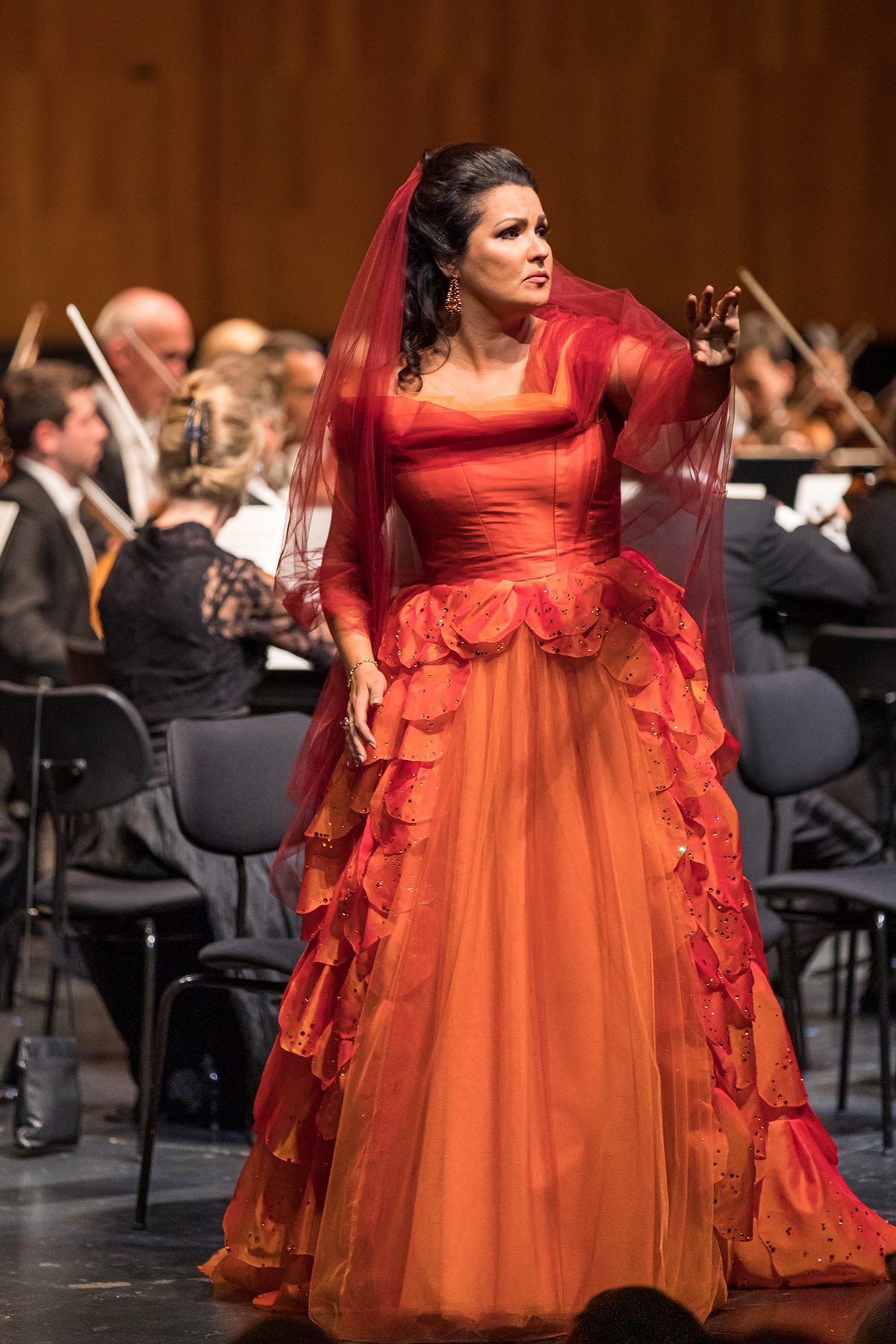Opera singer in an orange dress in performance