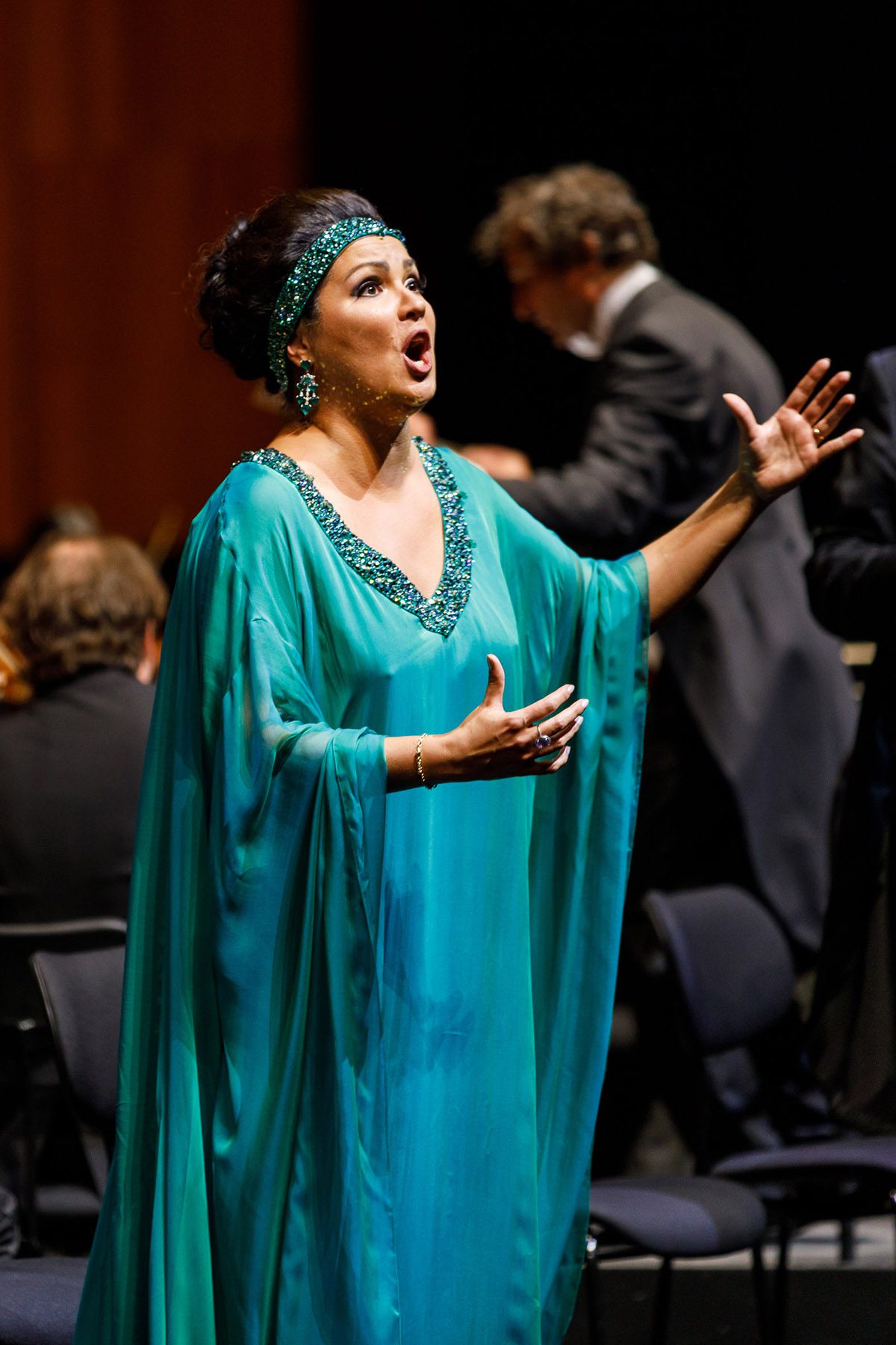 Female opera singer mid performance in a blue Arabian style dress