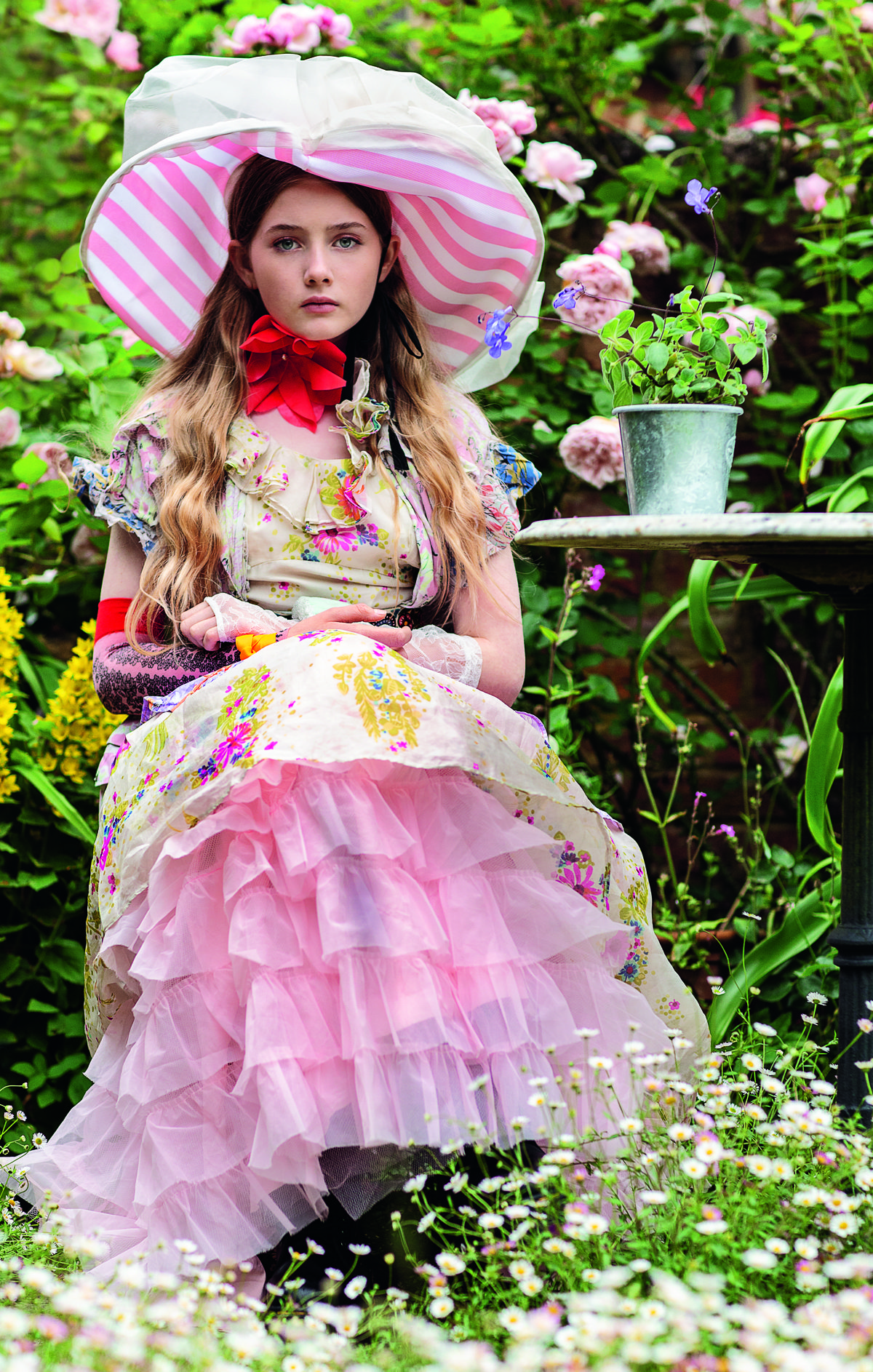 Young model poses in elaborate fashion and hat