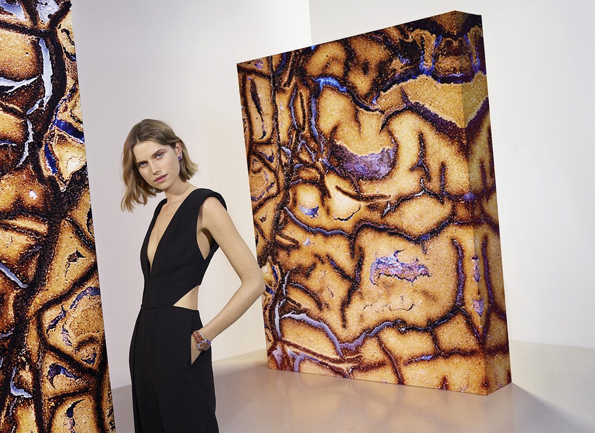 Model posing with large contemporary artworks