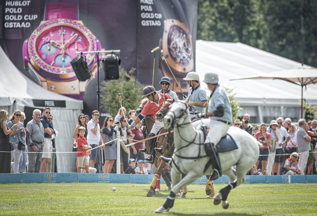 Polo players mid match with sticks raised