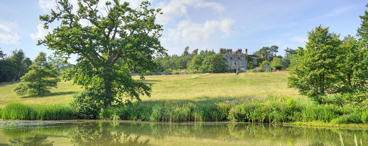 Country estate house with lush grounds and lake