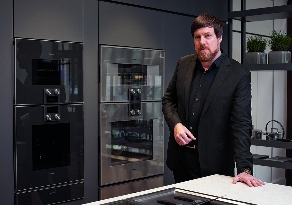 Man in a suit standing in high tech kitchen