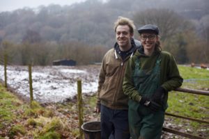 Two farmers standing in rugged landscape