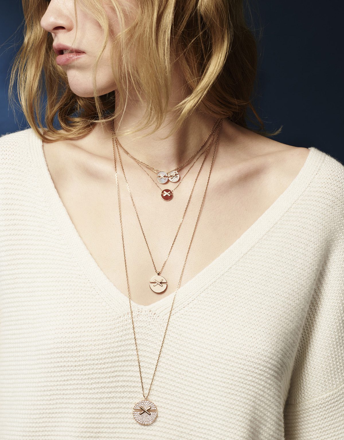 Model wearing layered necklaces