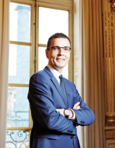 portrait of a man in a suit wearing glasses