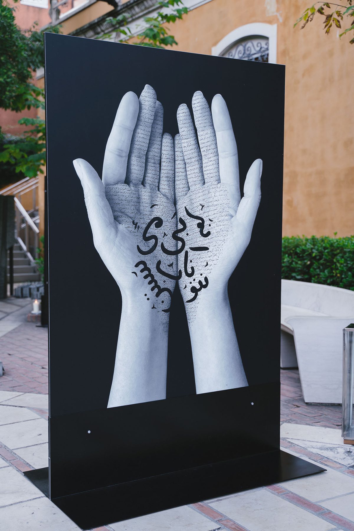 Monochrome image of hands inscribed with symbols