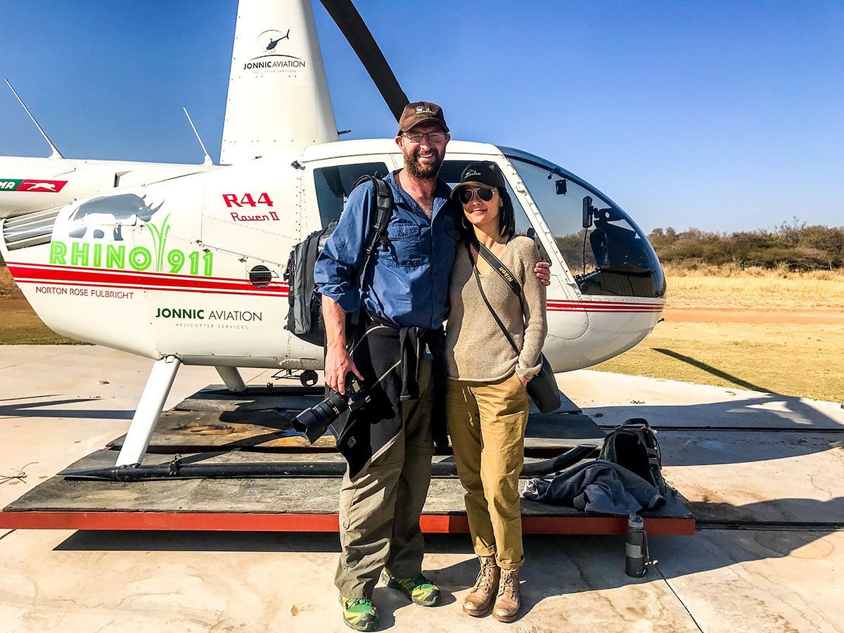 Man and woman standing by helicopter