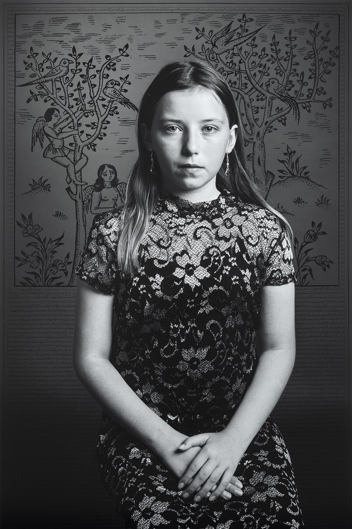 Portrait of a girl sitting in front of illustrated wall