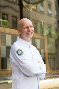Bald man wearing chef's jacket