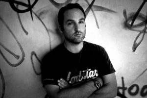 portrait of man standing against graffiti wall