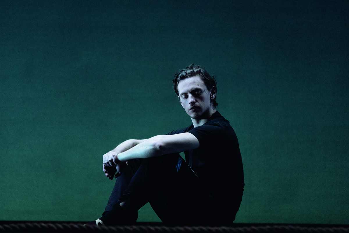 Dancer sitting against a green background