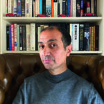 man in front of book shelf