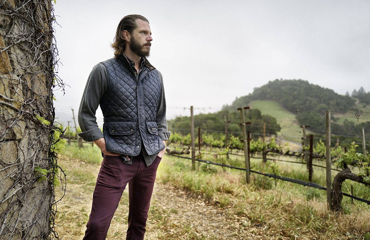 man looking out over vineyards