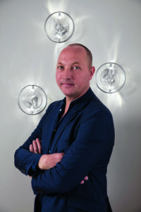 man standing in front of wall lights