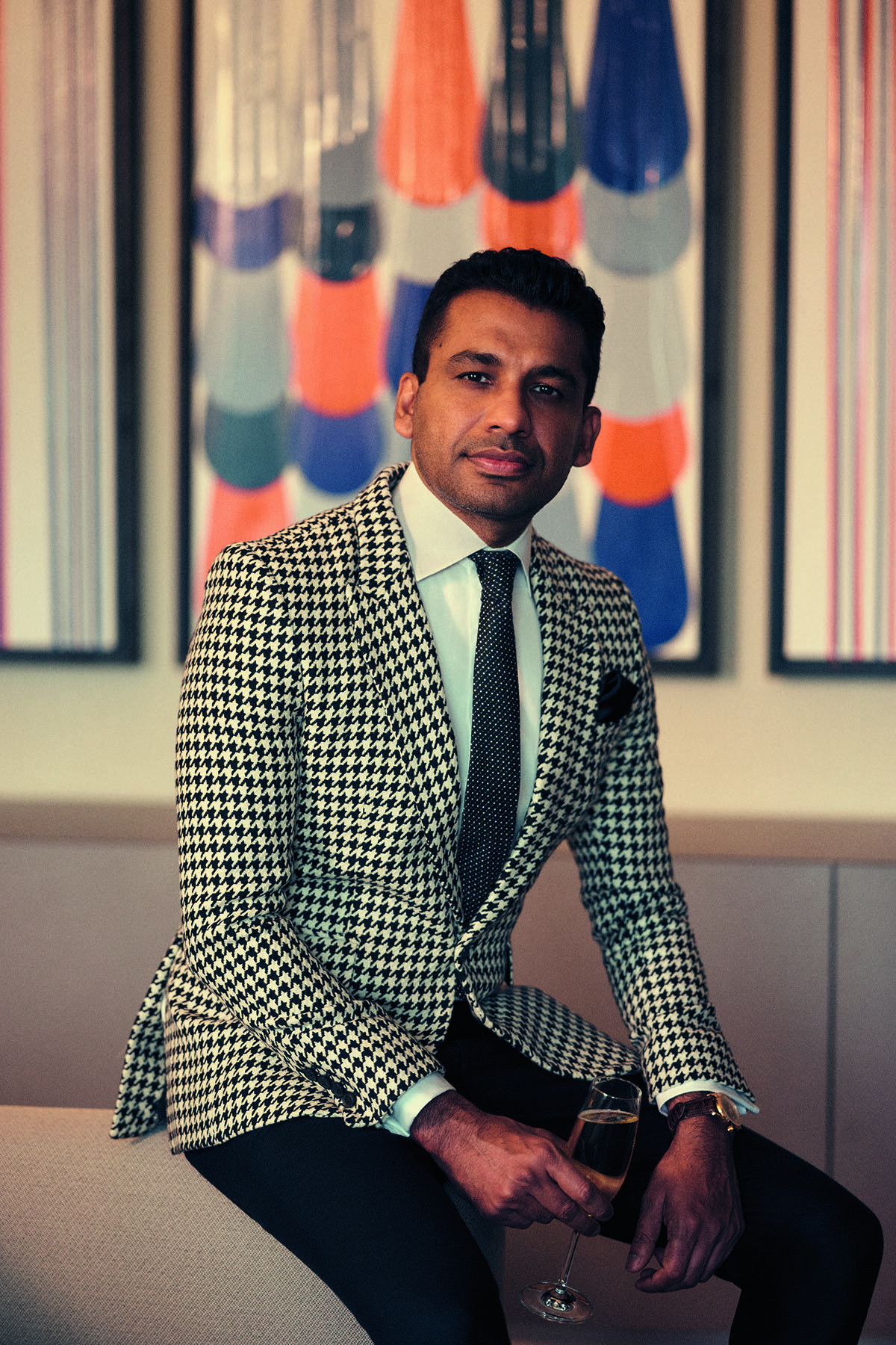 man in suit sitting on edge of table