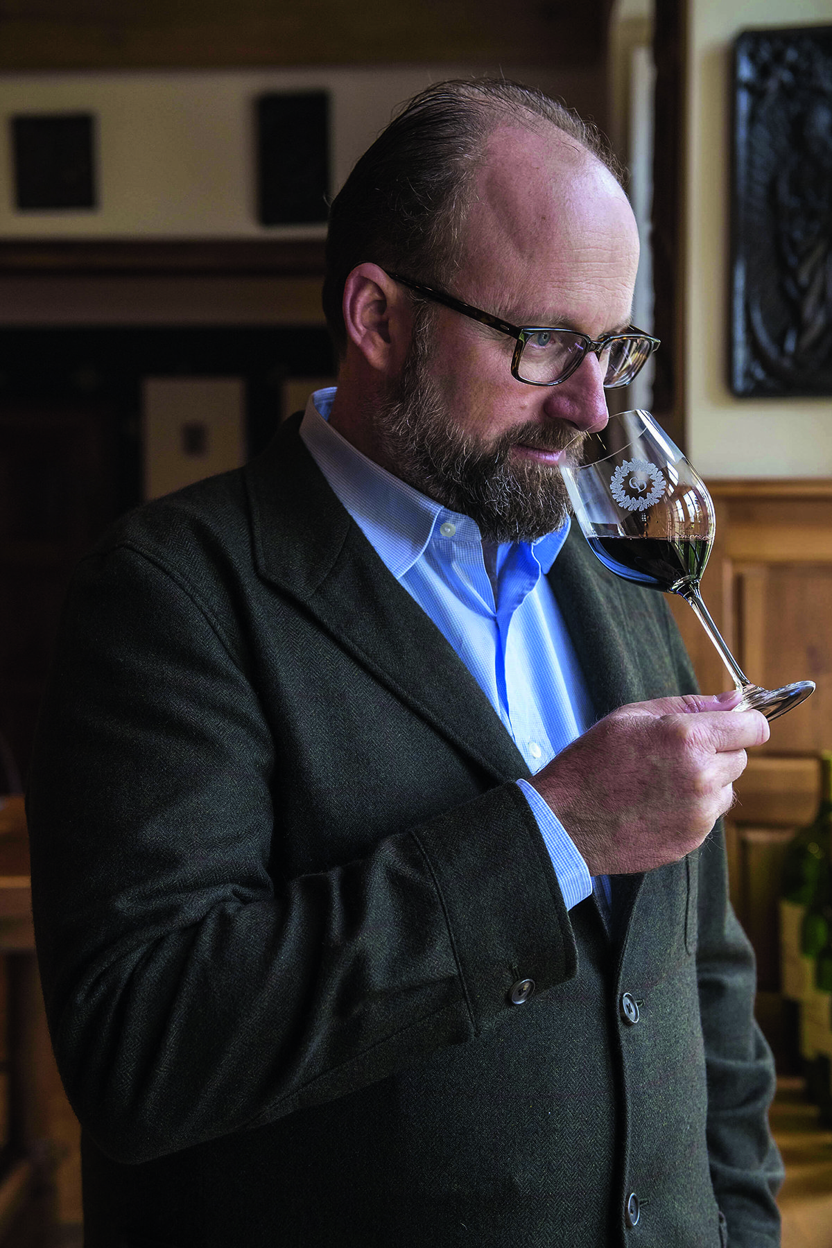 man sniffing glass of red wine