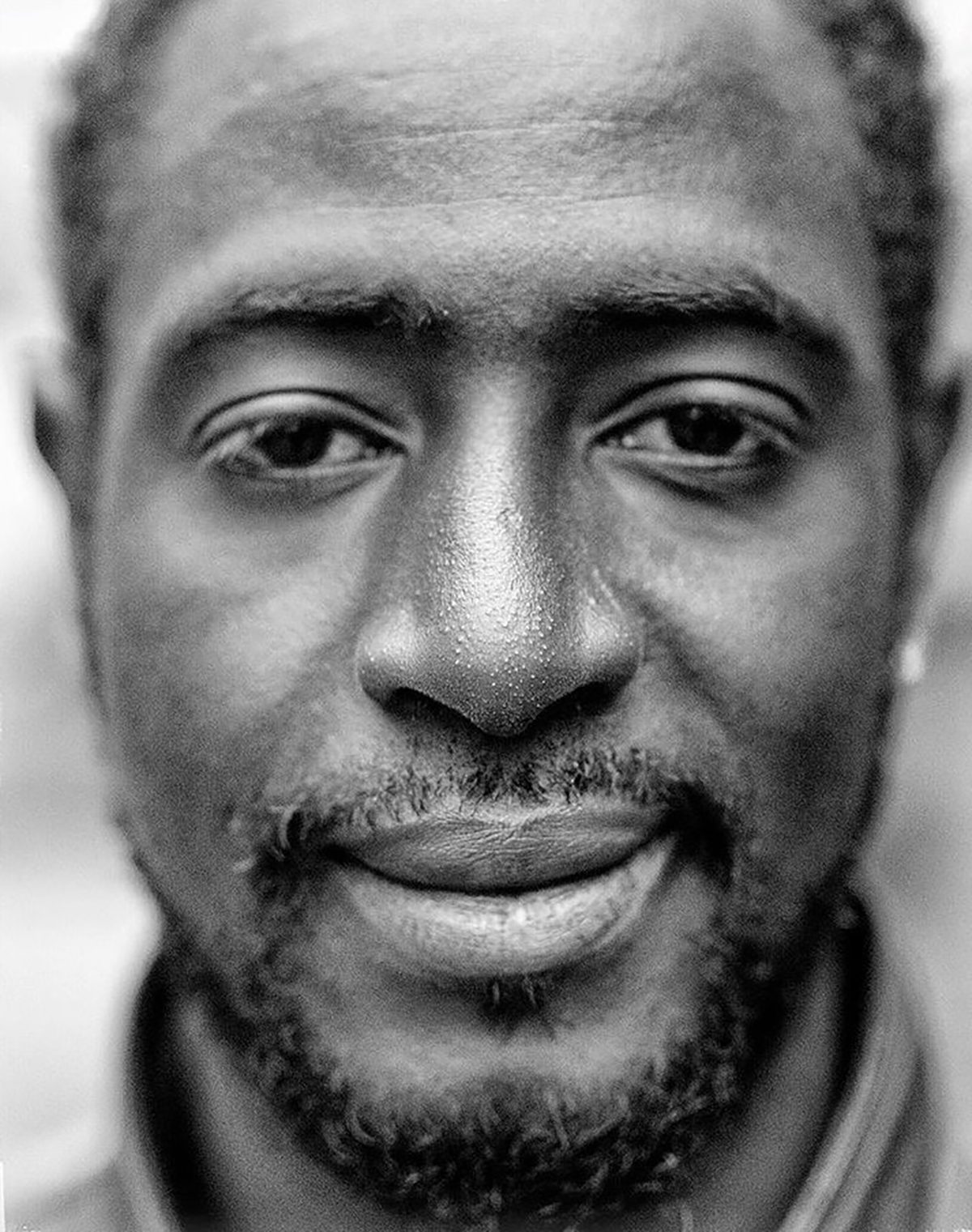 A close up of a black man with a moustache and beard