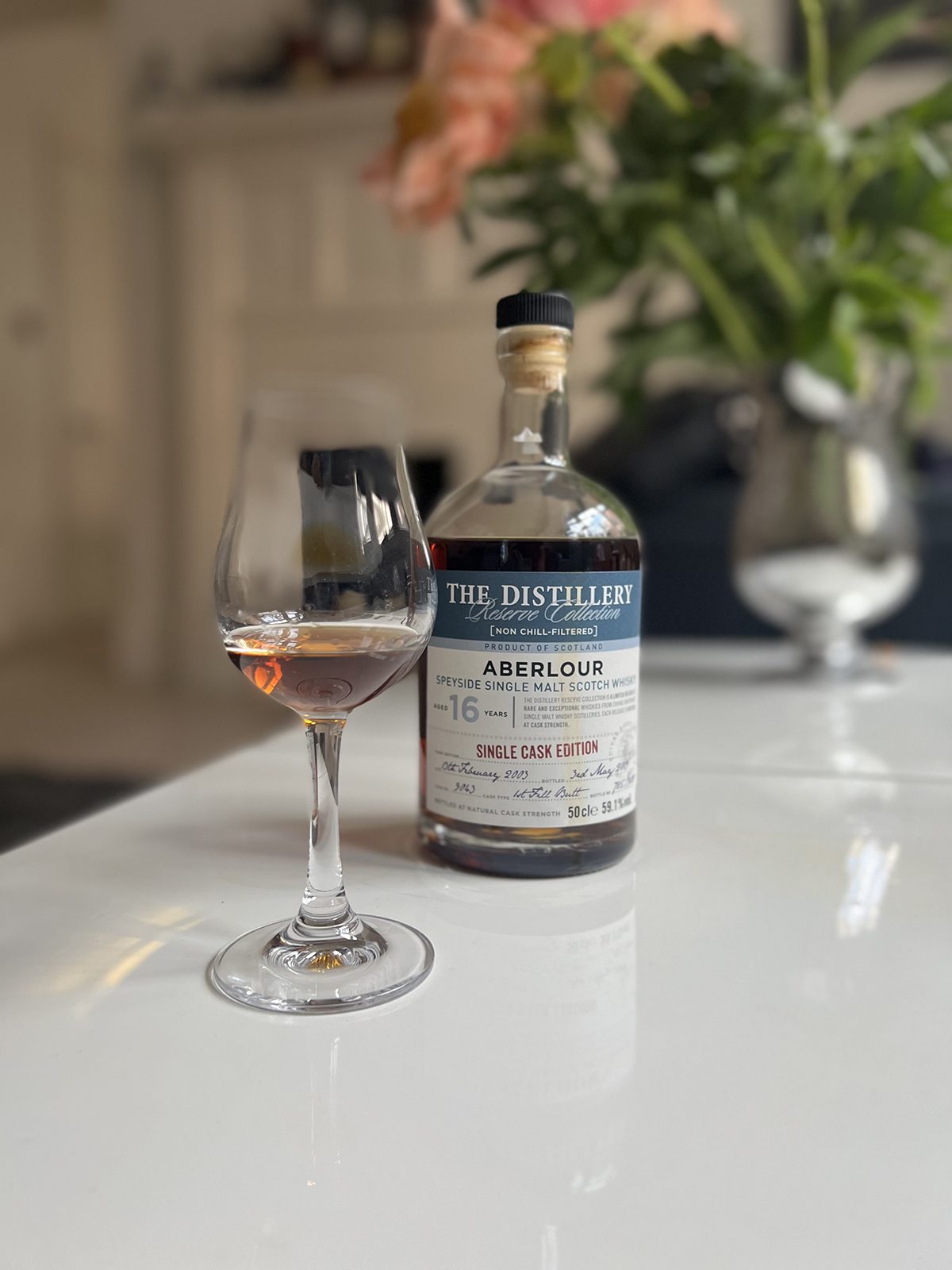 A bottle of Aberlour whiskey with a glass of whiskey on the table