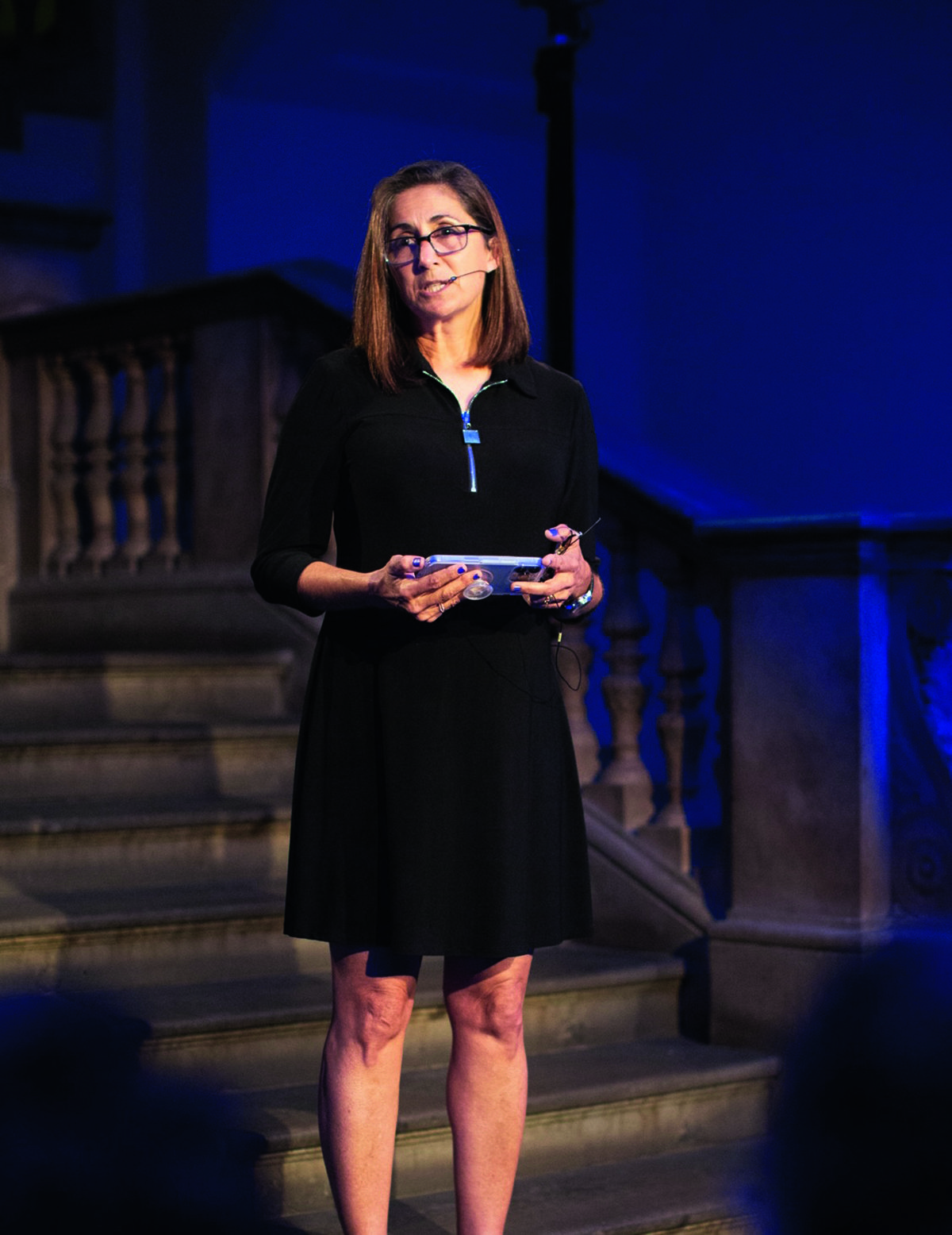 Nicole Stott wearing a black dress reading a speech