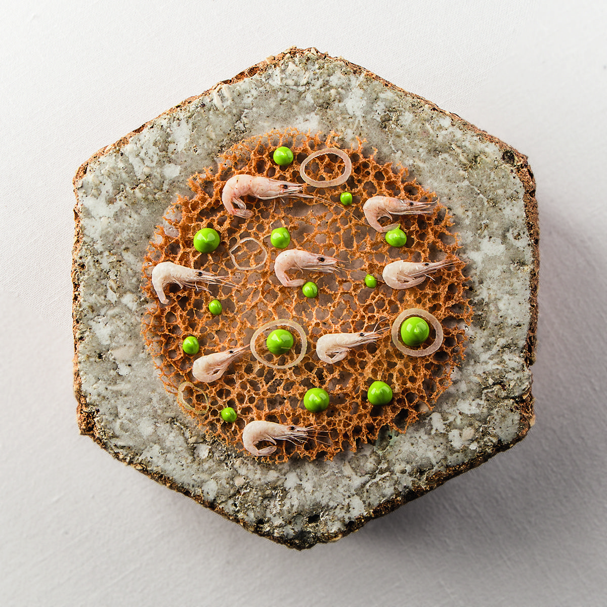 shrimps and peas on a large round cracker