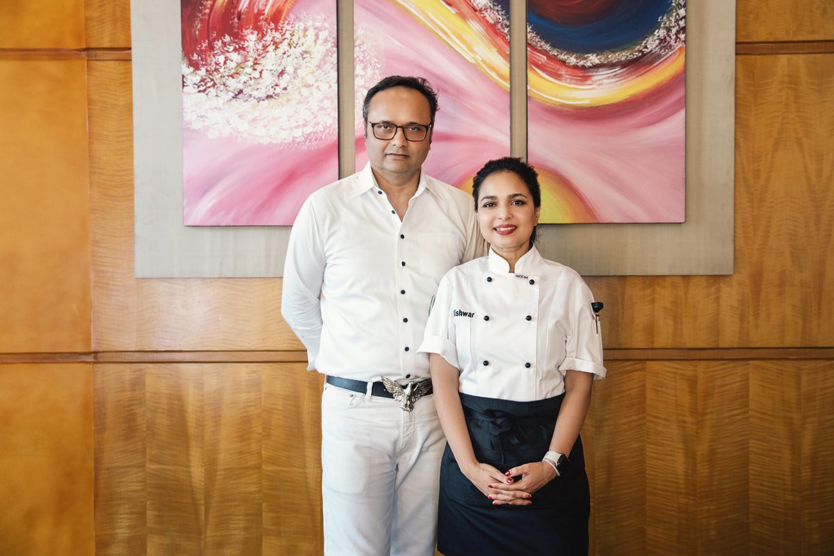 Durjoy Rahman in a white shirt standing next to Kishwar Chowdhury in a chef apron