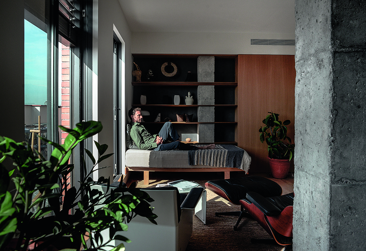 A man sitting down with plants around him
