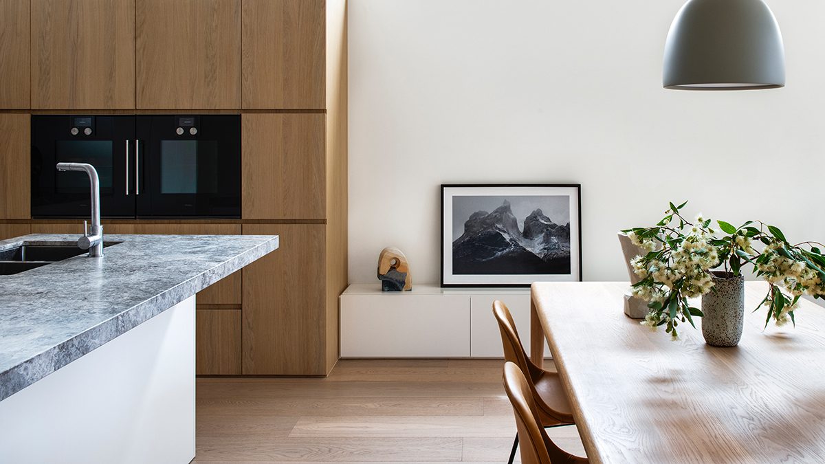 a kitchen with a white table and wooden unit