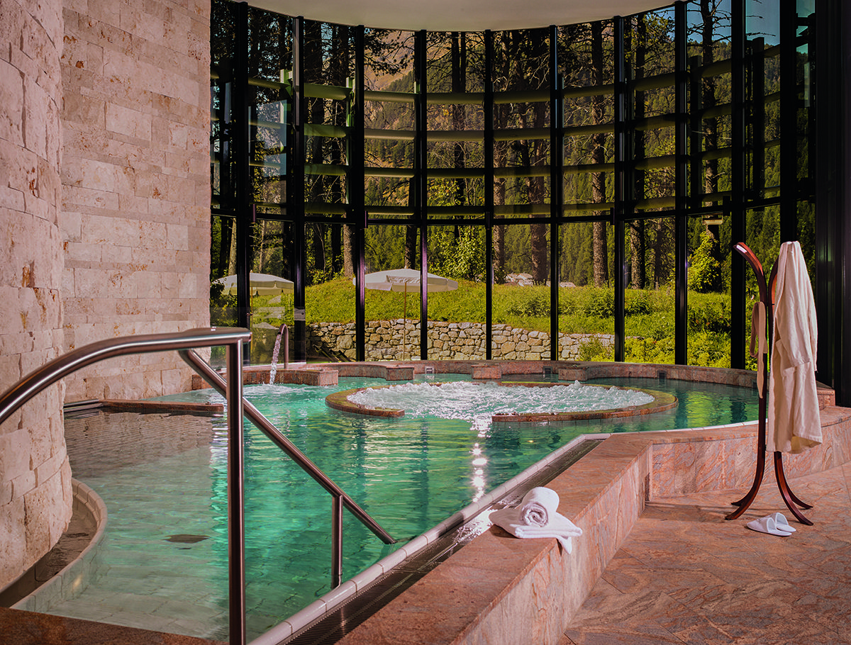 A whirlpool by a window with a forest outside