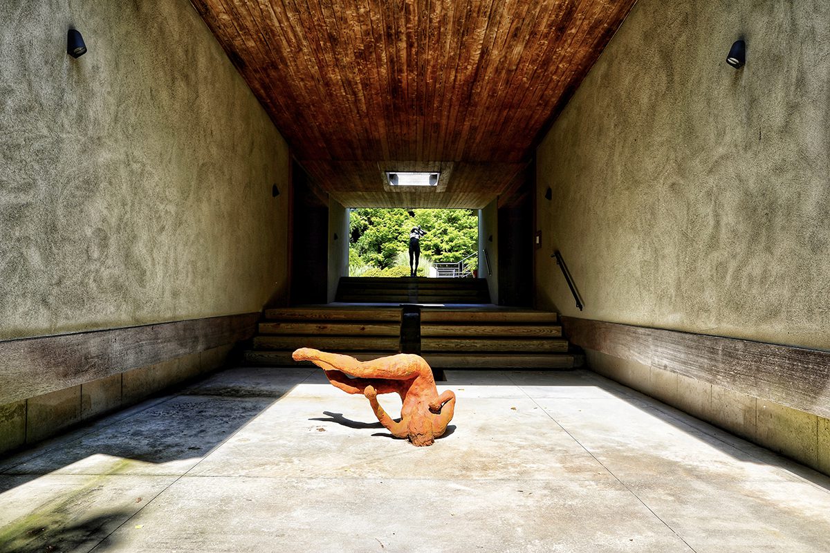 An orange statue below a set of stairs