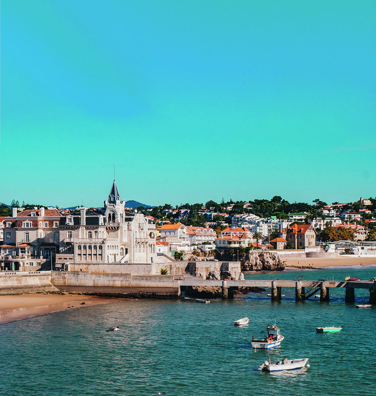 A town with white buildings by the sea and a pier