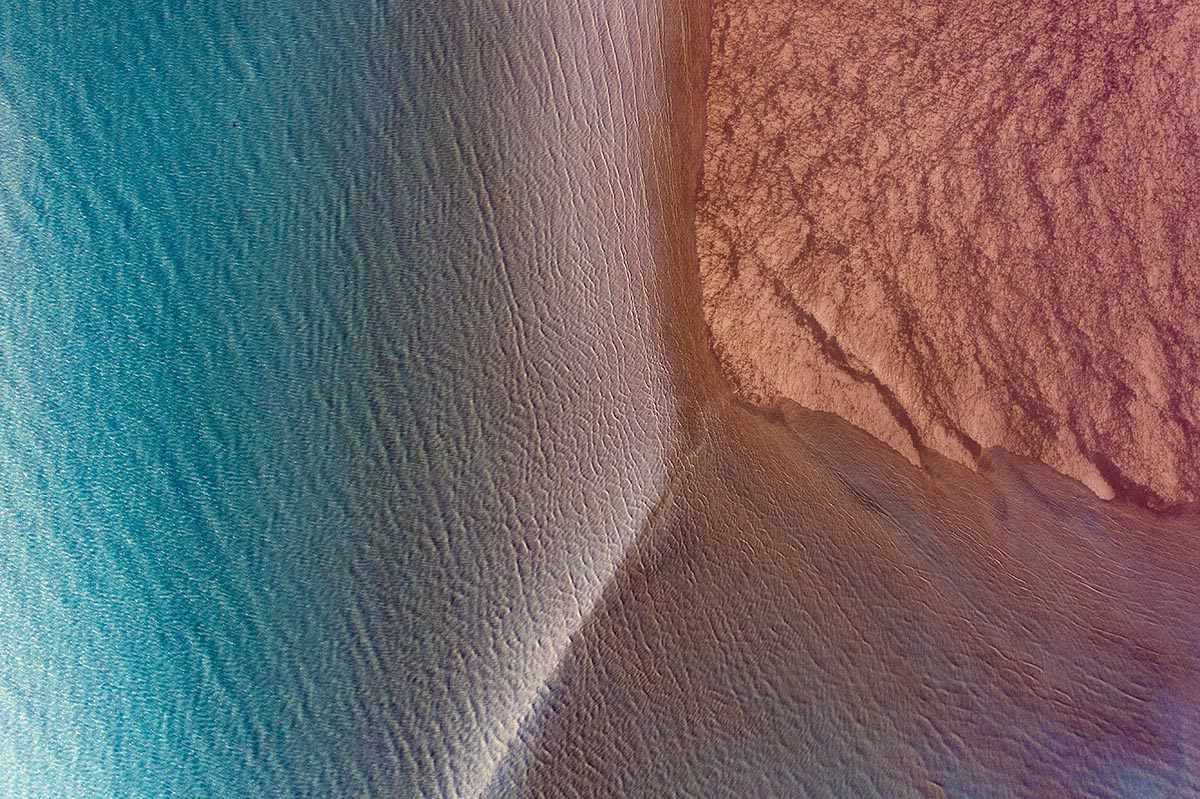 the blue sea by a red rock