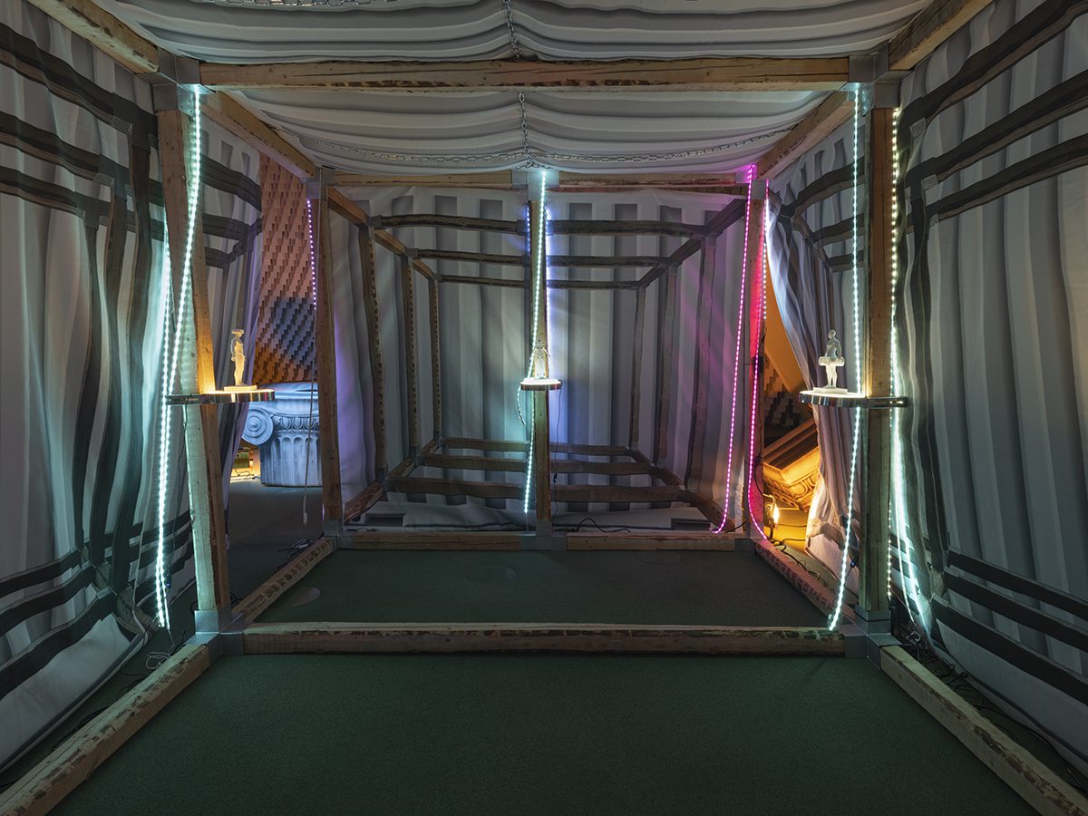 A tent with a green carpet and wooden beams