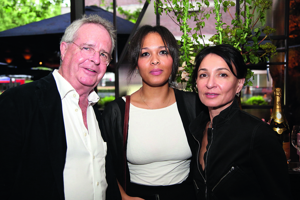 Two women and a man smiling for a photograph
