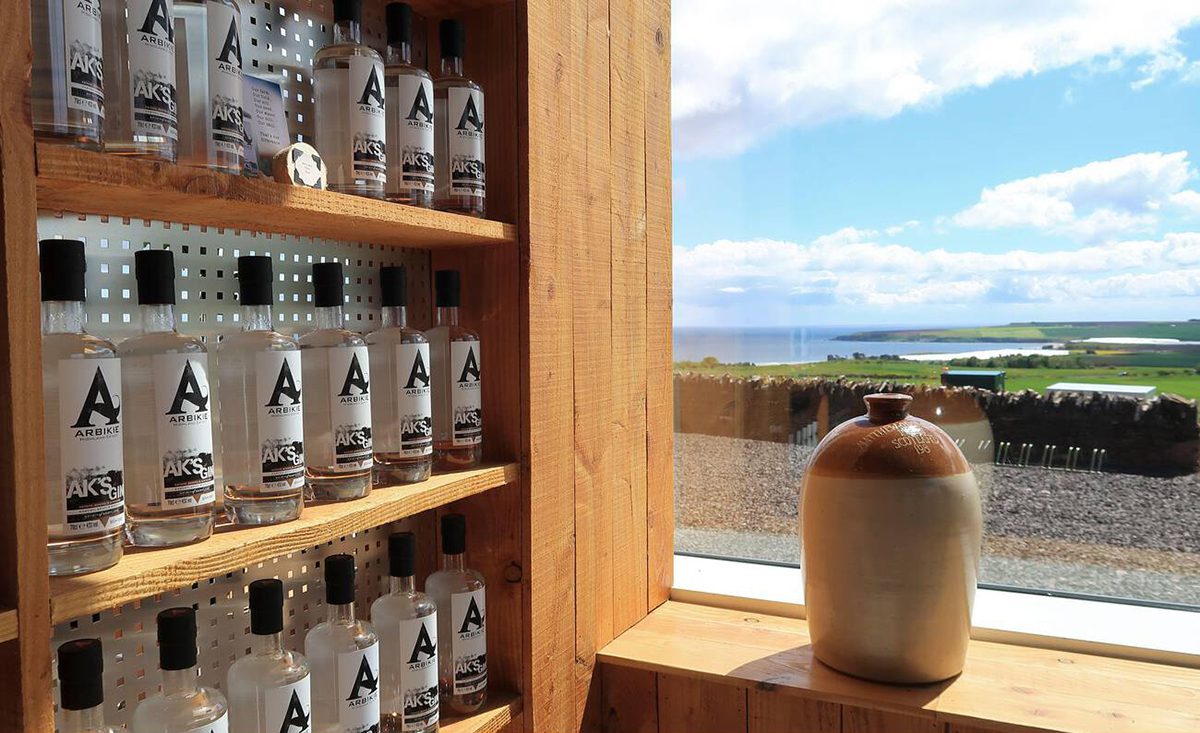 Whiskey on a shelf by a window overlooking the sea