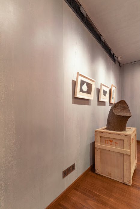A brown sculpture on a wooden plinth
