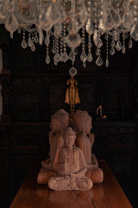 buddhist statues underneath a chandellier